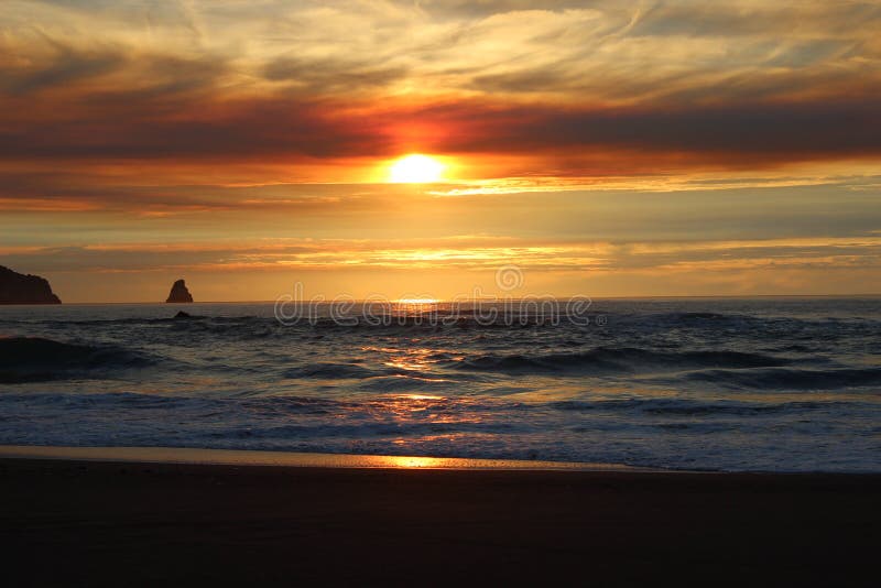 Cloudy skies and sunset over Oregon Coast Pacific ocean rocky outcrops