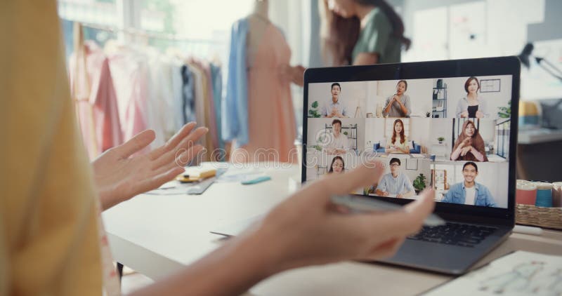 Cloup joven asia señora costurera usar laptop en una reunión con el equipo de diseñador multigráfico discutir muestra crear diseño metrajes