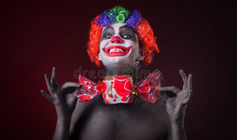 Clown effrayant avec le maquillage fantasmagorique et plus de sucrerie image libre de droits Clown effrayant avec le maquillage fantasmagorique et plus de sucrerie image libre de droits