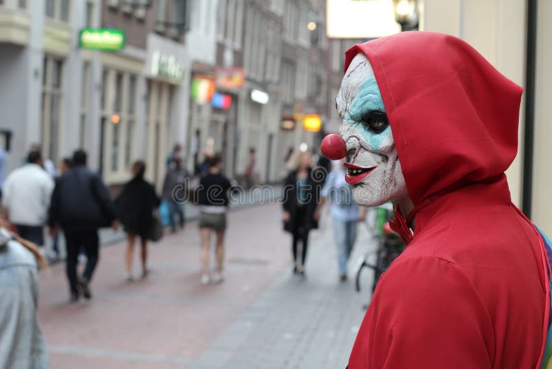 Clown fantasmagorique recherchant sa victime dans l'endroit serré photographie stock libre de droits Clown fantasmagorique recherchant sa victime dans l'endroit serré photographie stock libre de droits