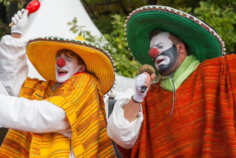 Two clowns in mexican traditional costumes with make-up and red noses singing and dancing. Two clowns in mexican traditional costumes with make-up and red noses singing and dancing.