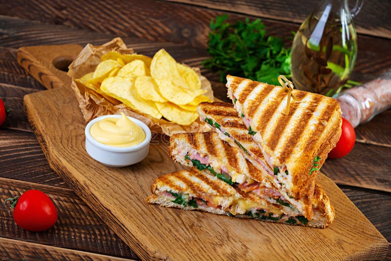 Club Sandwich with Ham, Cheese, Tomato, Salad and Chips Stock Photo