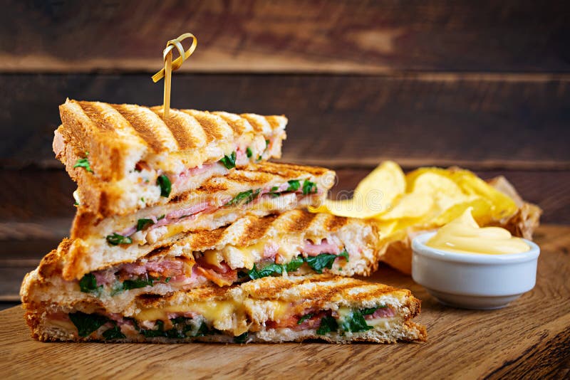 Club Sandwich with Ham, Cheese, Tomato, Salad and Chips Stock Photo