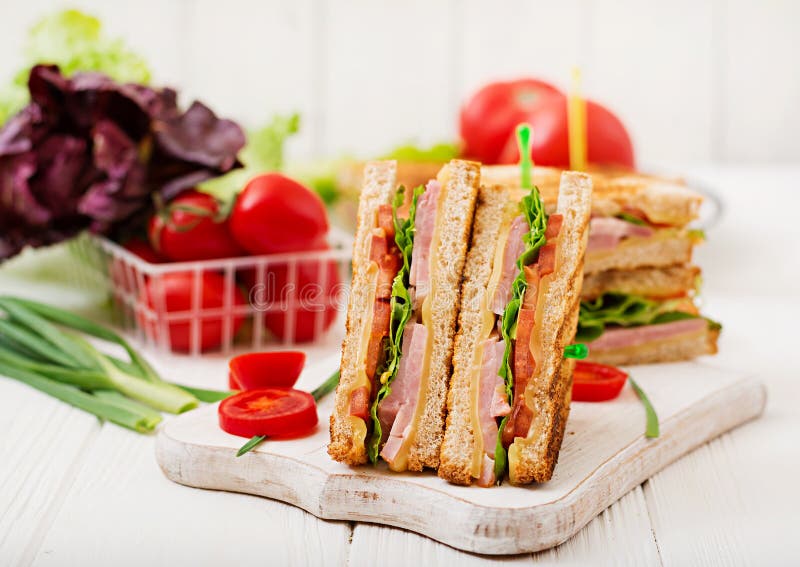 Club sandwich - panini with ham, cheese, tomato and herbs