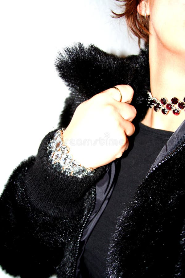 Grungy shabby chic club snapshot di donna che indossa un nero falso giacca di pelliccia e grande non corrispondenti gioielli strass.