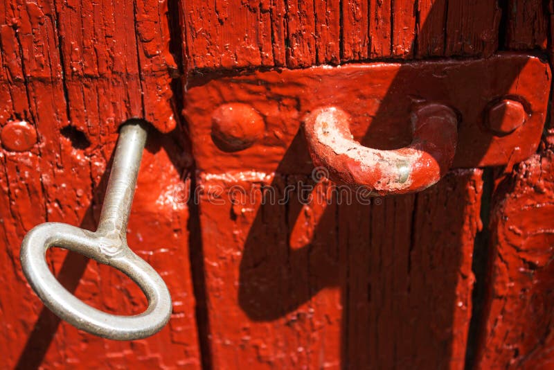 Clé antique de fer de la porte dans la vieille porte en bois rouge images libres de droits Clé antique de fer de la porte dans la vieille porte en bois rouge images libres de droits