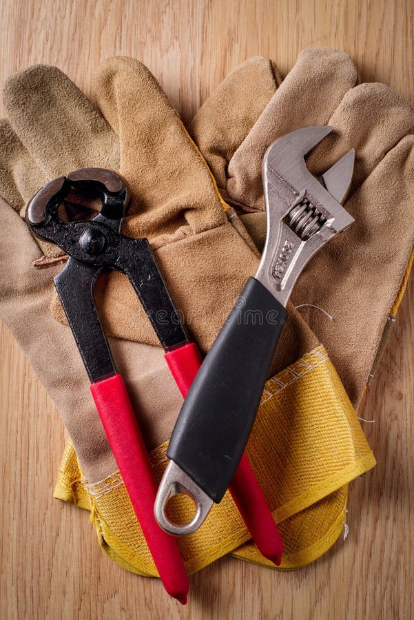 Clé réglable et extracteur de clou sur les gants protecteurs photos stock Clé réglable et extracteur de clou sur les gants protecteurs photos stock