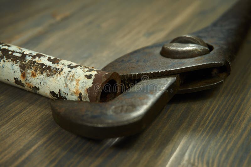 Clé à tube et tuyau rouillé sur le fond en bois foncé images libres de droits Clé à tube et tuyau rouillé sur le fond en bois foncé images libres de droits