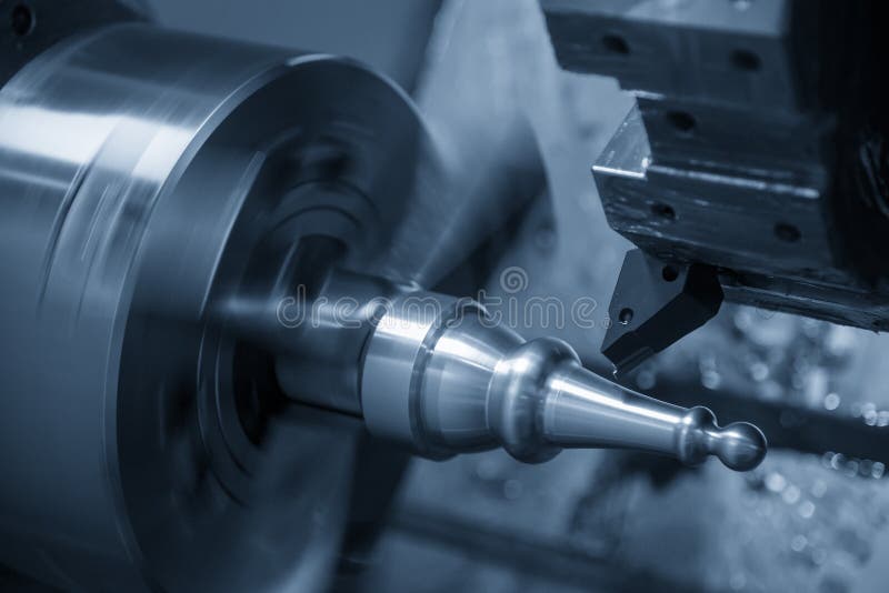 The CNC lathe machine in metal working process cutting the metal shaft parts with the cutting tools.