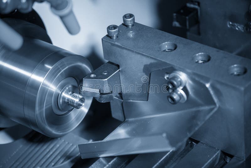 The CNC lathe machine in metal working process cutting the screw  parts with the cutting tools.