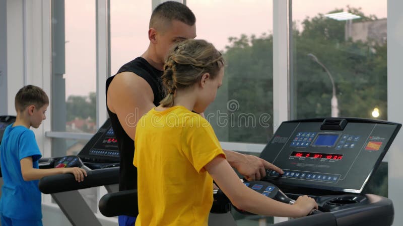 Coach helps children perform physical exercises in gym. sporty, healthy lifestyle, concept. Schoolchildren jogging and