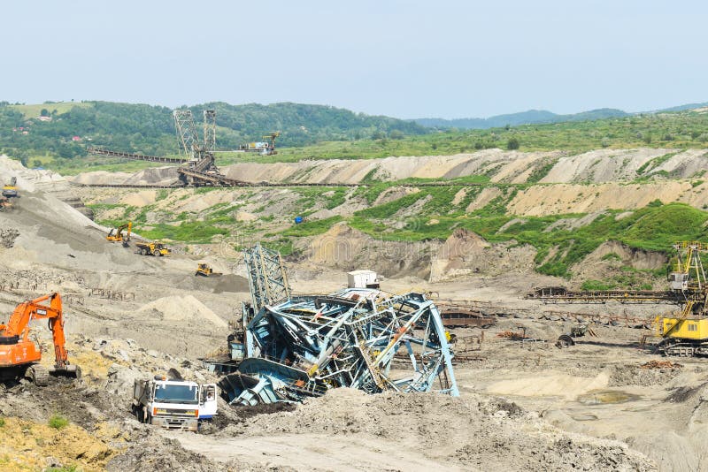 Coal mine accident with a heavy extraction machine inside the coal exploitation. The huge excavator collapsed in the open pit. royalty free stock photography Coal mine accident with a heavy extraction machine inside the coal exploitation. The huge excavator collapsed in the open pit. royalty free stock photography