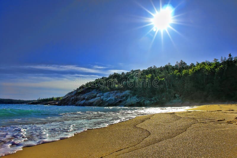 Sand beach on the Maine coast in Acadia National Park in late afternoon with glowing sun. Sand beach on the Maine coast in Acadia National Park in late afternoon with glowing sun