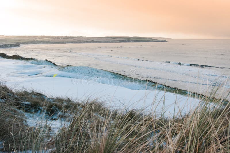 Coastal snow covered links golf course at sunset royalty free stock photo