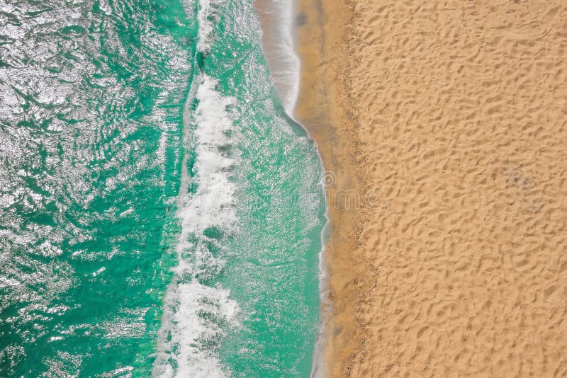 Coastline Beach Ocean waves with foam on the sand. Top view from drone