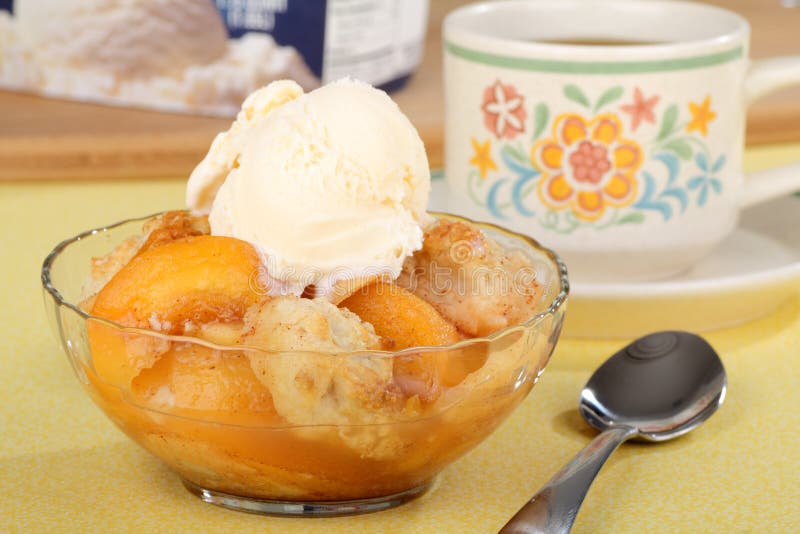 Peach cobbler with a scoop of ice cream in a bowl. Peach cobbler with a scoop of ice cream in a bowl