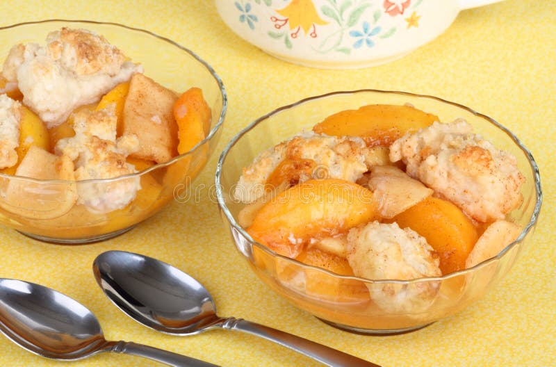 Two glass bowls of peach cobbler dessert. Two glass bowls of peach cobbler dessert