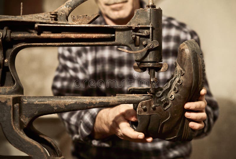 Cobbler at work with sewing machine. Cobbler at work with sewing machine