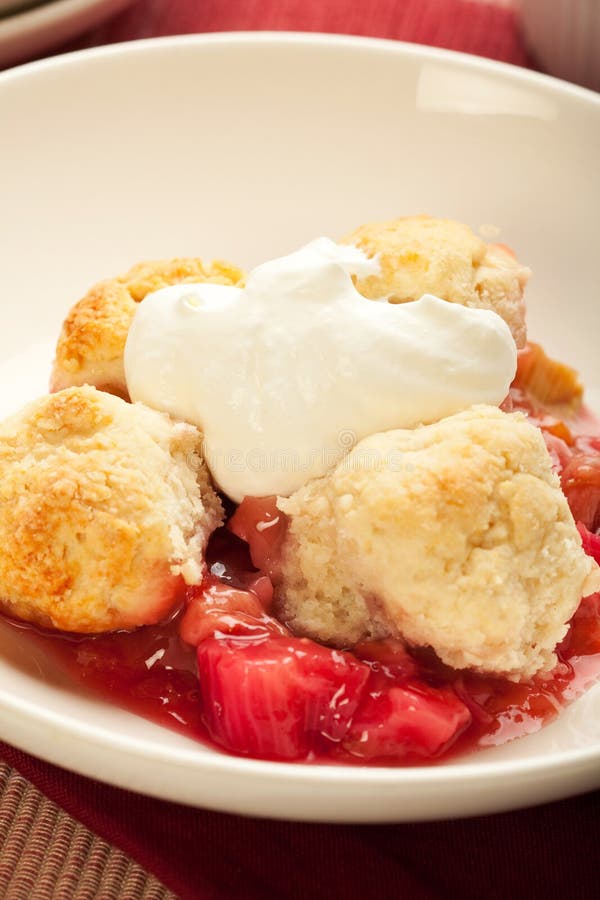 Fresh strawberry rhubarb cobbler with whipped cream. Fresh strawberry rhubarb cobbler with whipped cream