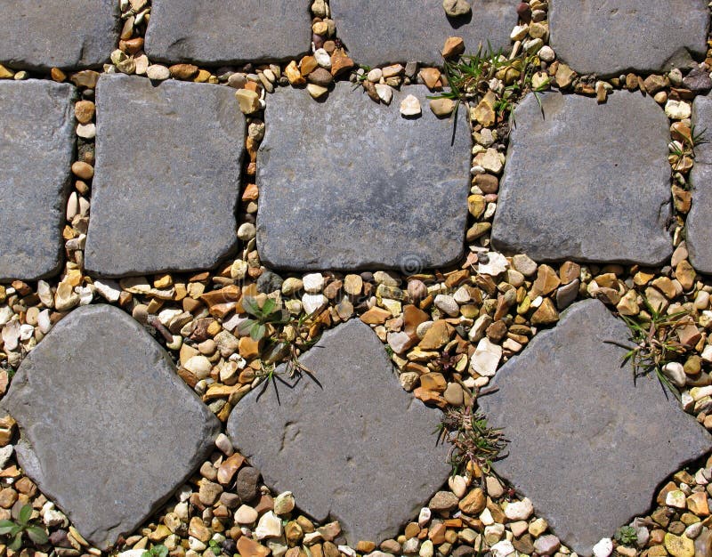 The end of a nice, natural, cobbled path, showing two different cobble patterns, with golden gravel and some weeds between the stones. The end of a nice, natural, cobbled path, showing two different cobble patterns, with golden gravel and some weeds between the stones