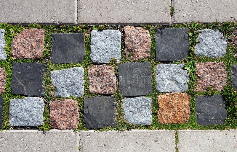 Cobblestone pavement overgrown with moss and grass