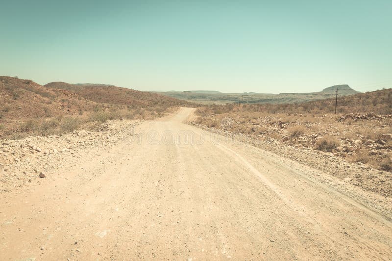 Cobrir o cruzamento de estrada de enrolamento o deserto de Namib, no parque nacional majestoso de Namib Naukluft, o melhor destin fotografia de stock royalty free Cobrir o cruzamento de estrada de enrolamento o deserto de Namib, no parque nacional majestoso de Namib Naukluft, o melhor destin fotografia de stock royalty free