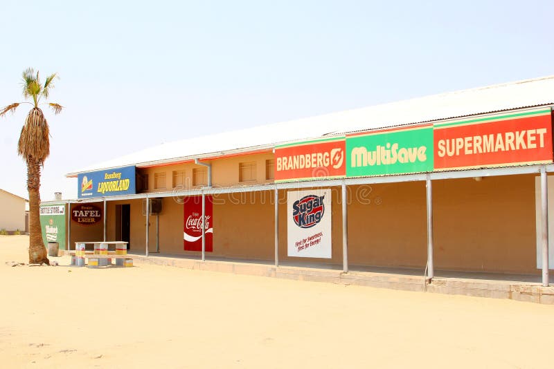 African shopping mall with a bottle stire, supermarket and commercial signs of Sugar King, Coca Cola, Liquorland, Multisave and Brandberg. In Uis, Damaraland, Namibia. Southern Africa. African shopping mall with a bottle stire, supermarket and commercial signs of Sugar King, Coca Cola, Liquorland, Multisave and Brandberg. In Uis, Damaraland, Namibia. Southern Africa.