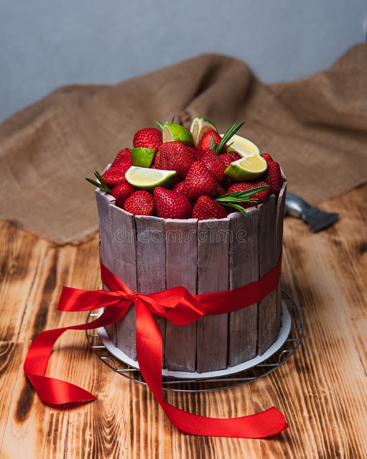 Coccinella e fragole. Dolci e fragole con calce e rosmarino con nastro rosso e ascia
