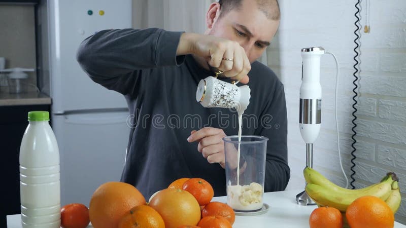 Cocción de un batido de plátano. manos mens pelar un plátano maduro y colocarlo en una licuadora para hacer una fruta vegana salud almacen de metraje de vídeo