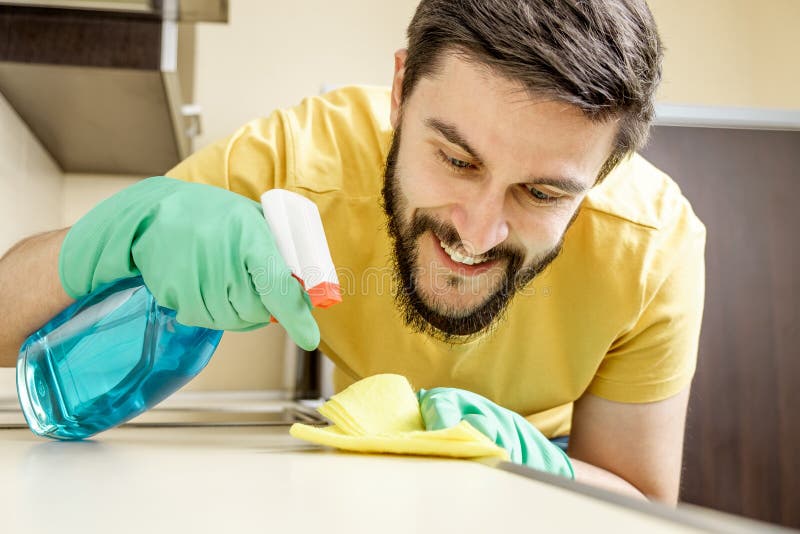 Cocina masculina de la limpieza del portero con la esponja fotografía de archivo Cocina masculina de la limpieza del portero con la esponja fotografía de archivo