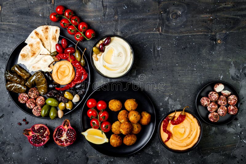 Cocina tradicional árabe El disco medio-oriental del meze con la pita, aceitunas, hummus, rellenó el dolma, bolas del queso del l foto de archivo Cocina tradicional árabe El disco medio-oriental del meze con la pita, aceitunas, hummus, rellenó el dolma, bolas del queso del l foto de archivo