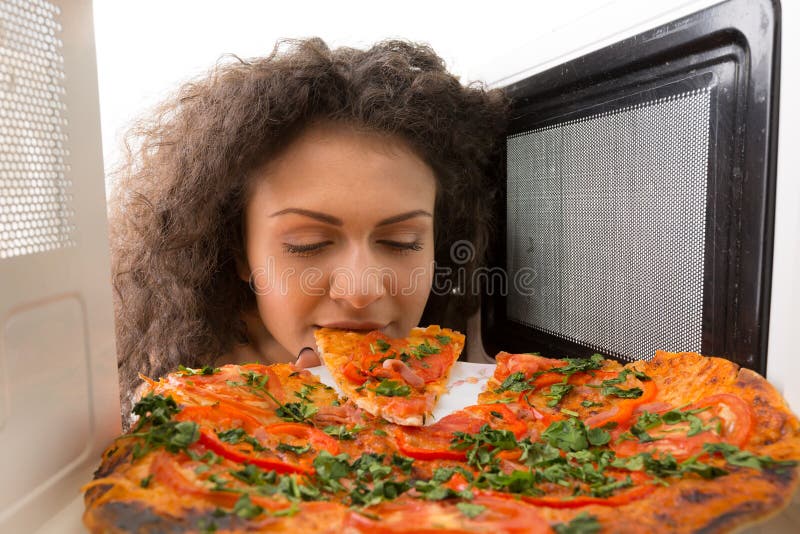 Cocinar la pizza en la microonda foto de archivo libre de regalías Cocinar la pizza en la microonda foto de archivo libre de regalías