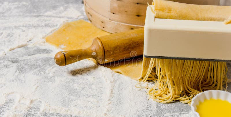Cocinar los tallarines El fabricante de las pastas con un rodillo y un huevo imágenes de archivo libres de regalías Cocinar los tallarines El fabricante de las pastas con un rodillo y un huevo imágenes de archivo libres de regalías
