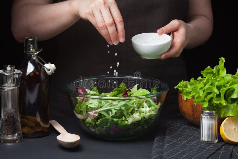 Cocinero de la mujer en la cocina que prepara la ensalada vegetal Consumición sana Adiete el concepto Una manera de vida sana Par imagen de archivo libre de regalías Cocinero de la mujer en la cocina que prepara la ensalada vegetal Consumición sana Adiete el concepto Una manera de vida sana Par imagen de archivo libre de regalías