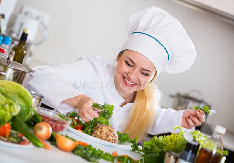 Cocinero de sexo femenino que adorna el queso con las hierbas y la lechuga imágenes de archivo libres de regalías Cocinero de sexo femenino que adorna el queso con las hierbas y la lechuga imágenes de archivo libres de regalías