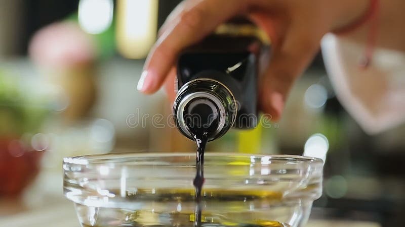 Cocinero de Sous que vierte el vinagre balsámico en el aliño de ensaladas del aceite de oliva, comida sana almacen de metraje de vídeo