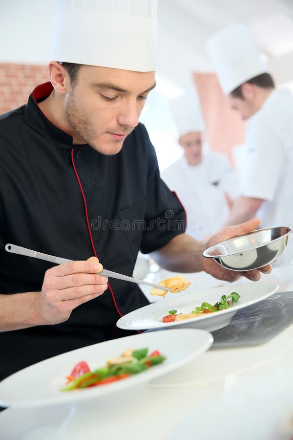 Cocinero en el restaurante que prepara el plato imagenes de archivo Cocinero en el restaurante que prepara el plato imagenes de archivo