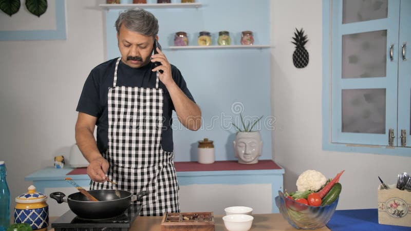 Cocinero masculino indio profesional añadiendo especias a su comida cocina de estilo casero en la cocina india