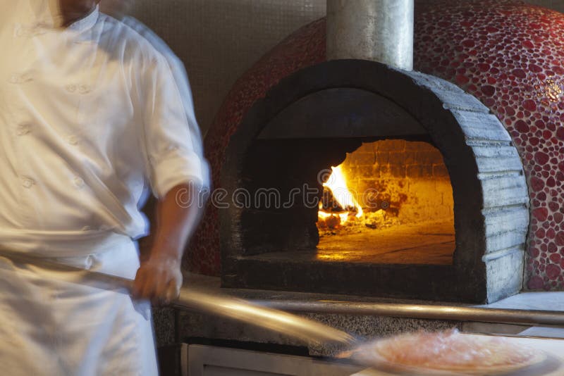 Cocinero que prepara la comida en una cocina comercial fotos de archivo libres de regalías Cocinero que prepara la comida en una cocina comercial fotos de archivo libres de regalías