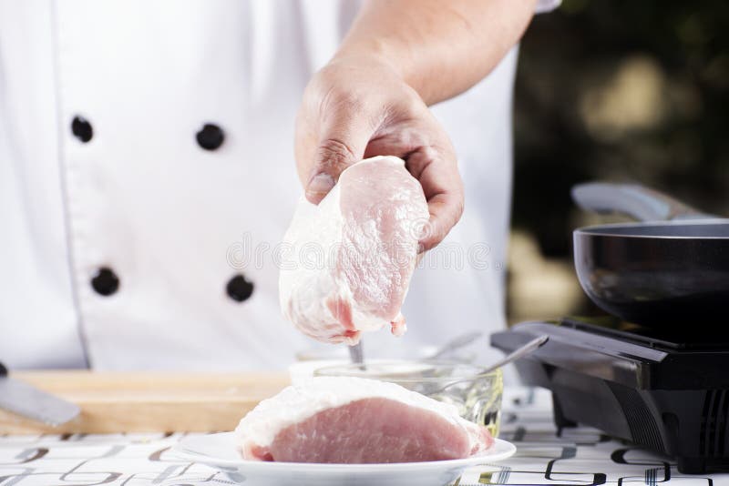 Cocinero que sostiene el cerdo crudo foto de archivo libre de regalías Cocinero que sostiene el cerdo crudo foto de archivo libre de regalías