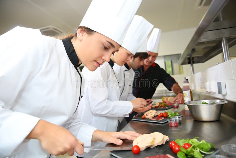 Cocineros jovenes que preparan la charcutería