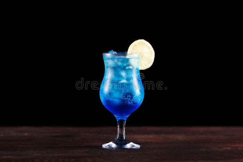 Cocktail alcoolique bleu glacé régénérateur avec la tranche de citron, d froid image libre de droits Cocktail alcoolique bleu glacé régénérateur avec la tranche de citron, d froid image libre de droits