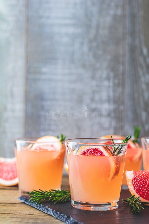 Cocktail alcoólico cor-de-rosa fresco com toranja, gelo e alecrins fotografia de stock royalty free Cocktail alcoólico cor-de-rosa fresco com toranja, gelo e alecrins fotografia de stock royalty free