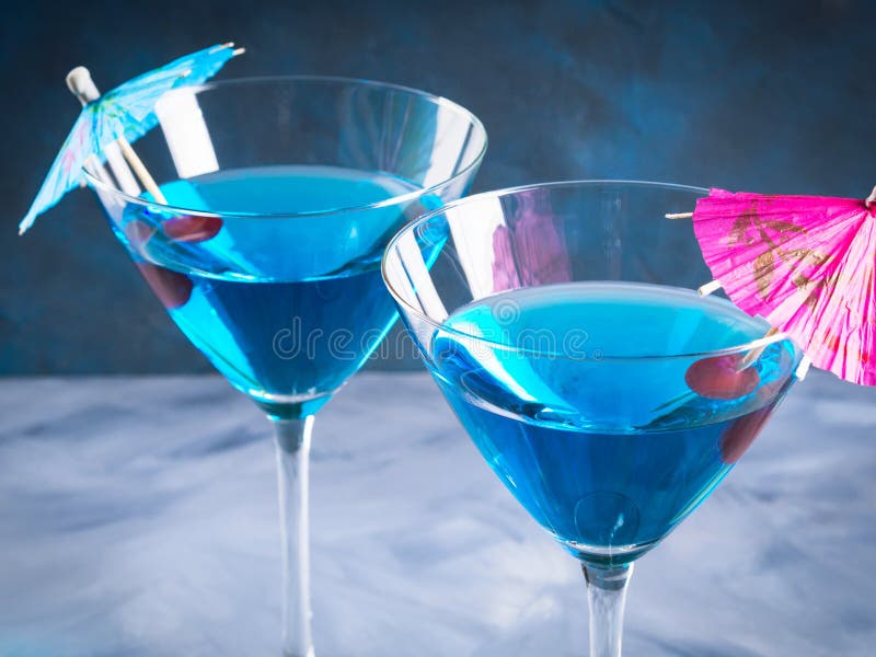 Cocktail bleu en verre de martini avec le parapluie photographie stock Cocktail bleu en verre de martini avec le parapluie photographie stock