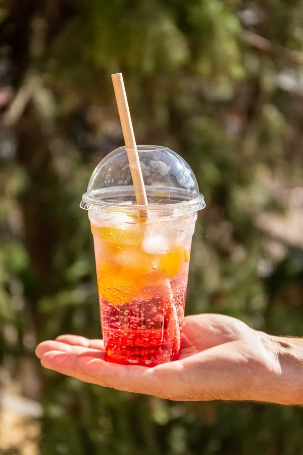 Cocktail De Fruits Avec De La Glace Dans Un Verre En Plastique. Boisson  Estivale. Verre De Limonade à La Main. Retrait De Concept. Photo stock -  Image du alcool, été: 225505888