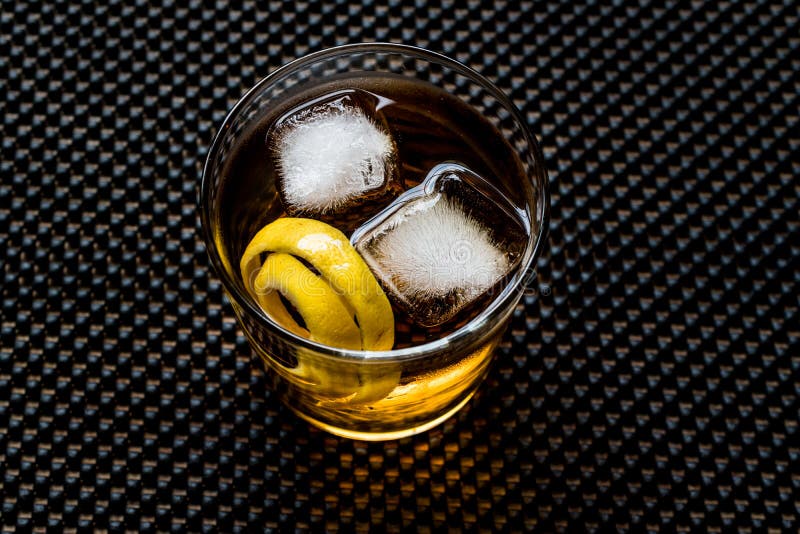 Cocktail di Highball con la buccia ed il ghiaccio di limone fotografia stock Cocktail di Highball con la buccia ed il ghiaccio di limone fotografia stock