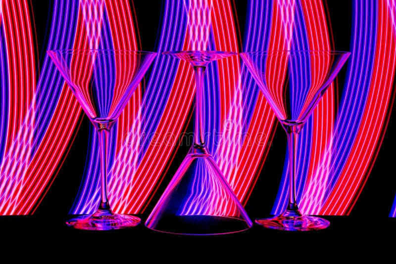 Cocktail / martini glasses with neon light behind royalty free stock images Cocktail / martini glasses with neon light behind royalty free stock images