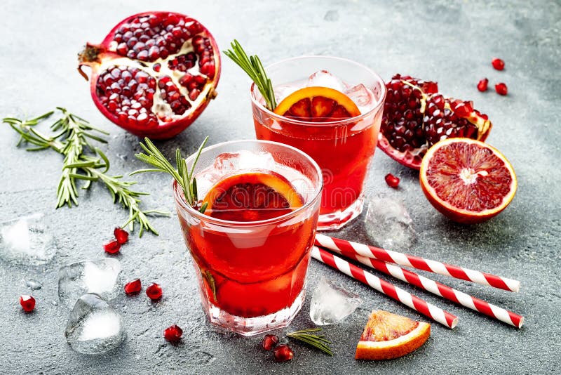 Cocktail rosso con l'arancia sanguinella ed il melograno Bevanda di rinfresco di estate Aperitivo di festa per la festa di Natale