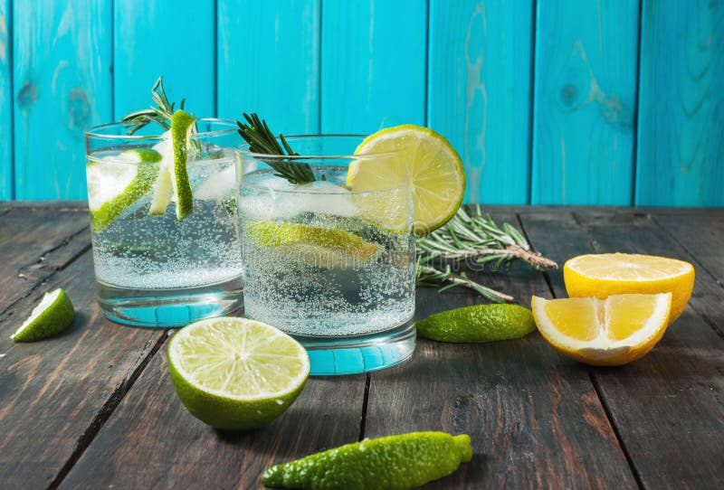 Cocktail tonique de genièvre de boisson alcoolisée avec le citron, le romarin et la glace sur la table en bois rustique photos libres de droits Cocktail tonique de genièvre de boisson alcoolisée avec le citron, le romarin et la glace sur la table en bois rustique photos libres de droits