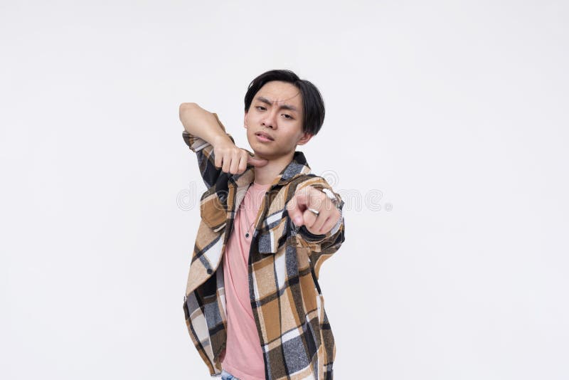 A cocky young man makes a throat-slit gesture with hand while pointing straight at camera, saying you're dead meat. stock photos